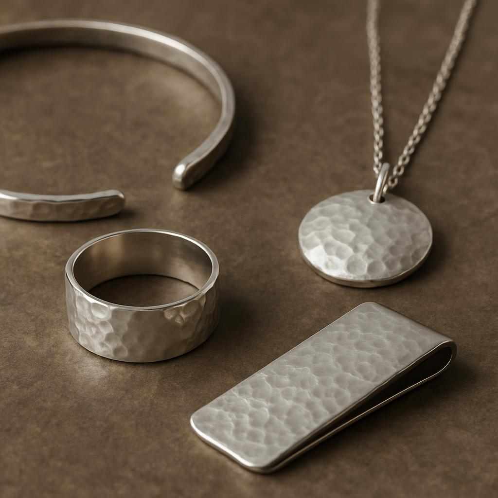 A collection of silver jewelry pieces, each featuring a hammered metal finish. The pieces include a cuff, ring, necklace w...